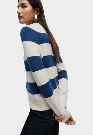 Pull rayé bleu marine et crème, en tissu tricoté avec une coupe décontractée, doté de manches longues et de poignets côtelés.