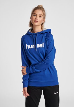 Felpa con cappuccio blu con un grande logo bianco "hummel" sul petto. Presenta un cappuccio foderato in grigio e polsini e orlo a costine.