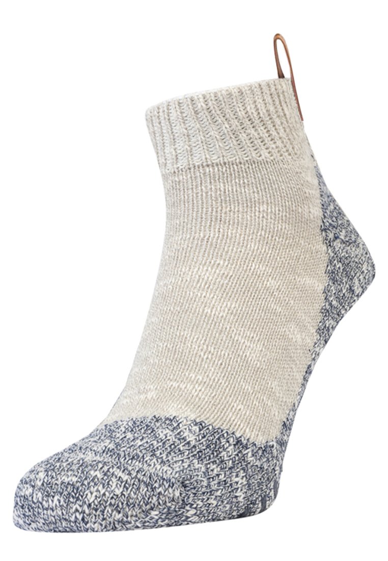 Calcetín hasta la rodilla en beige con una parte superior texturizada y un puño y puntera en azul marled oscuro. Presenta un pequeño lazo en la parte trasera para facilitar su uso.