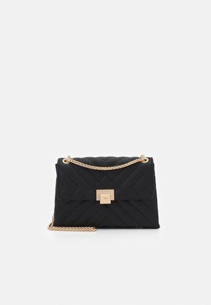 Borsa nera trapuntata con tracolla a catena dorata e chiusura quadrata. Il design include motivi a chevron evidenti su una superficie testurizzata.