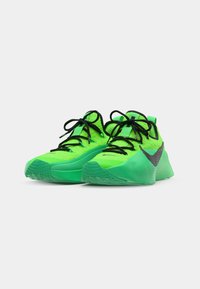 Baskets de sport vert vif avec une tige texturée, des lacets noirs et un accent noir en swoosh. Design léger avec une semelle épaisse.