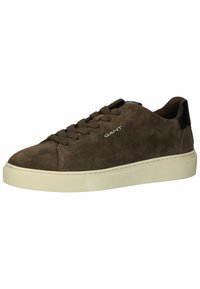 Braune Wildledersneaker mit Gummisohle, runden Schnürsenkeln und einem schwarzen Lederakzent an der Ferse. Logo auf der Seite gedruckt.