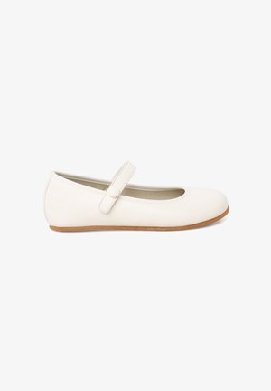 Weißer Mary-Jane-Flachschuh mit einem einzelnen, geknöpften Riemen und einer hellbraunen Sohle, seitlich auf weißem Hintergrund gezeigt.