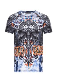 T-Shirt mit kurzen Ärmeln, das ein schwarz-weißes Grafikdesign mit Schädeln und Flügeln zeigt, akzentuiert mit orangefarbenen und blauen Details auf einem Batik-Hintergrund.