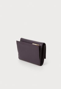 Portefeuille en cuir violet avec une finition texturée, présentant un design à rabat et une poche latérale pour cartes ou espèces. Forme compacte et fonctionnelle.