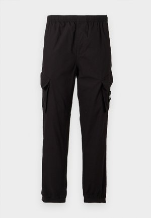 Pantaloni cargo neri con vita elastica, gambe affusolate, due tasche laterali e tessuto testurizzato. Presenta una piccola etichetta con logo su una tasca.