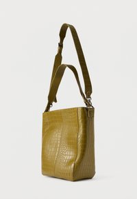 Olivenebrun toteveske med krokodillepreget tekstur, utstyrt med bred stropp og en strukturert, rektangulær form.