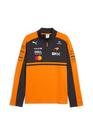 Pull sportif à manches longues orange et noir avec fermeture éclair et plusieurs logos de sponsors, dont Puma, Dell, Mastercard et DP World.