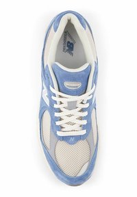 Blue and beige New Balance running shoe with white laces and mesh detailing, viewed from above on a white background.