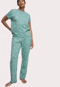 Kortærmet pyjamassæt i mintgrøn med hvide hjerte-mønstre; blødt bomuldsstof, afslappet pasform og bukser med lige ben.