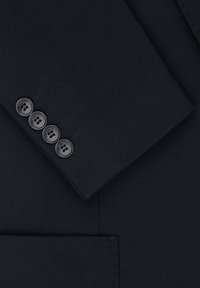 Czarna marynarka z tkaniny o fakturowym wykończeniu. Posiada klapę w stylu notch, cztery czarne guziki na mankiecie oraz boczną kieszeń.