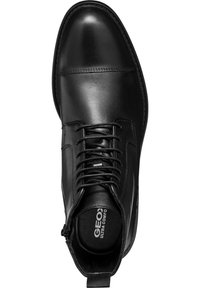 Bota de cuero negro hasta el tobillo con punta redonda, cierre de cordones en la parte frontal y costuras sutiles. Presenta un acabado suave y una plantilla acolchada.