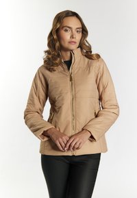 Beige gewatteerde jacket met een hoge kraag, volledige rits en goudkleurige hardware. Voorzien van zijzakken en gestikte details.