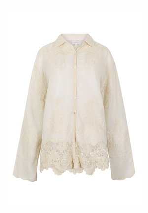 Blouse crème à manches longues avec boutons, broderie florale en dentelle et ourlet festonné.