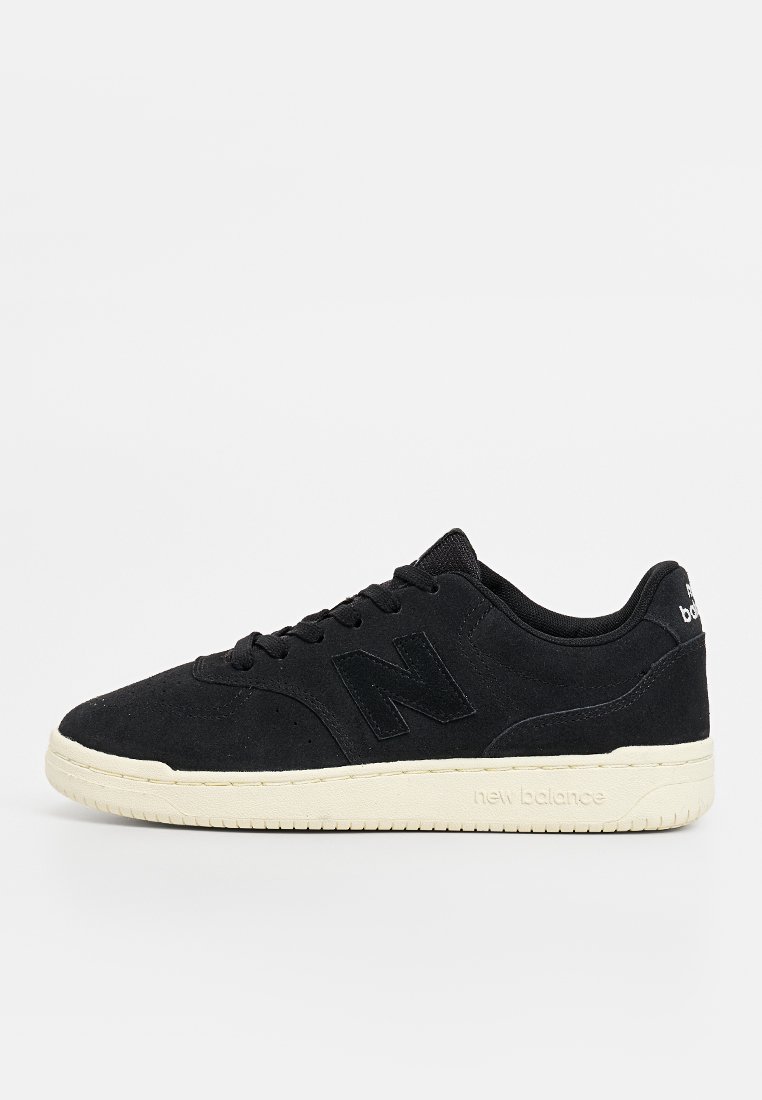 Zapatillas negras de ante con un diseño de corte bajo, que cuentan con un acabado texturizado, suela de goma blanca y un sutil logotipo en el talón y en el lateral.