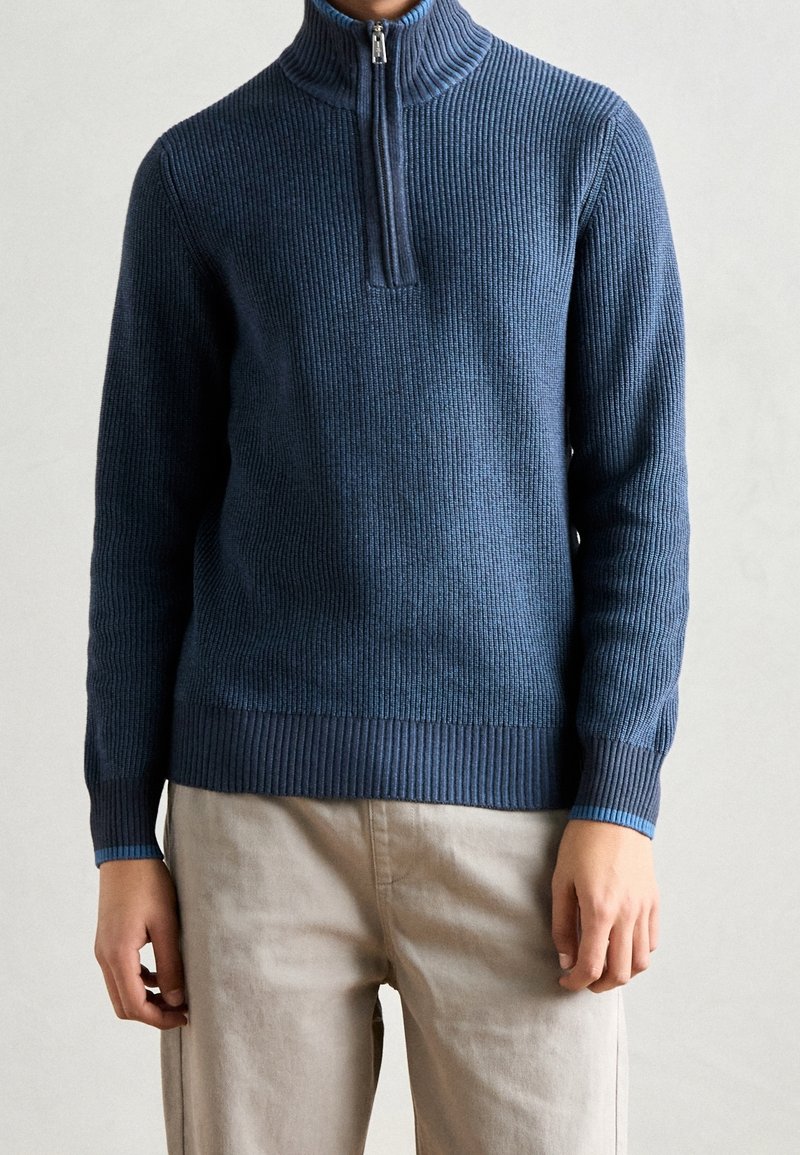 Maglione blu navy a coste con collo mezza cerniera, caratterizzato da un motivo a maglia strutturata e polsini in contrasto di colore azzurro chiaro.