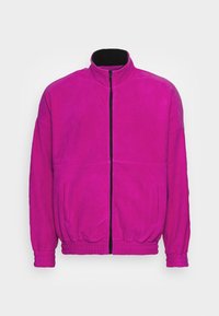 Giacca in pile con zip di un vivace magenta, caratterizzata da un colletto alto, polsini elasticizzati e tasche laterali con una elegante zip nera.