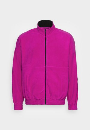 Fleece zip-up jacket in vibrant magenta, featuring a high collar, elastic cuffs, and side pockets with a sleek black zipper.