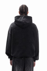 Μαύρο φαρδύ φούτερ με κέντημα με υφή στην πλάτη, με κουκούλα και ριχτούς ώμους. Το υλικό φαίνεται μαλακό και ζεστό.