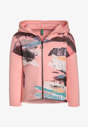 Pink hættetrøje med lynlås med abstrakte flerfarvede malerilignende mønstre og delvis sort tekst på fronten og skuldrene.