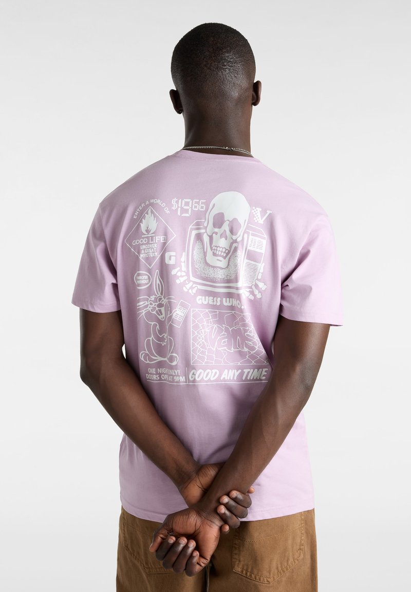 Camiseta de algodón de color púrpura claro con una impresión gráfica en la parte posterior, que incluye una calavera, un personaje de dibujos animados y elementos de texto. Mangas cortas.