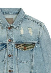 Giacca di jeans azzurro chiaro con una texture sdrucita, caratterizzata da strappi, chiusure con bottoni marroni e una tasca con accentuazione in camouflage. Macchiata di giallo.