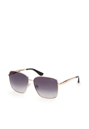 Gafas de sol cuadradas con montura metálica dorada, lentes oscuras degradadas, puntas negras en las patillas y un sutil grabado de la marca en las lentes y las varillas.