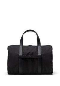 Crna torba od platna s kožnim trakama. Ima cilindrični oblik, gornje ručke i prednje kopčanje na dugme.