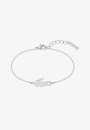 Bracciale in argento con charm logo coccodrillo. Chiusura regolabile con un'etichetta rettangolare incisa con "LACOSTE". Design semplice.