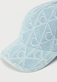 Ανοιχτό μπλε καπέλο από υφασμάτινη υφή με διακριτικό μοτίβο ρόμβου και γείσο, με ραφές που τονίζουν το σχέδιο.