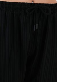 LELA SLIM FIT - Hlače - black