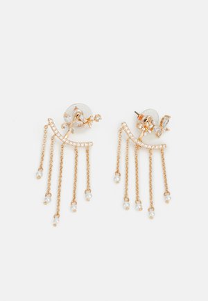 Los pendientes en tono dorado presentan cadenas en cascada con pequeñas perlas de agua dulce y gemas claras, creando un diseño en capas y flecos.