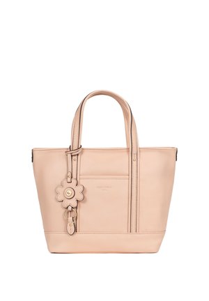 Borsa tote beige in pelle con doppi manici e portachiavi a forma di fiore attaccato a un manico, tasca frontale e dettagli di cuciture discrete.