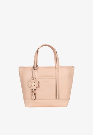 Beige leather tote bag with double handles and a flower-shaped keychain attached to one handle, front pocket, and subtle stitching details.