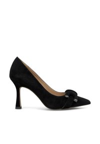 Scarpa nera in suede con tacco alto, punta affusolata e dettaglio a nodo decorativo sul davanti. Dotata di un sottile tacco a stiletto e fodera in pelle.