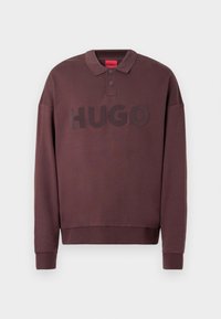 Langærmet mørkebrun polo-sweatshirt med ribkant ved ærmerne, to knapper ved kraven og "HUGO" trykt på brystet.