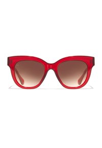 Piros macskaszem napszemüveg átlátszó kerettel és barna, átmenetes lencsékkel. Széles szárak finom márkajelzéssel az oldalukon.