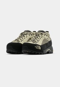 Barna és fekete túracipő, texturált felsőrésszel, tartós gumitalppal, megerősített orral és oldalsó márkajelzéssel ellátott fűzőrendszerrel.