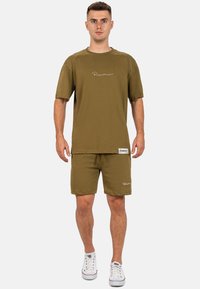 T-shirt a maniche corte verde oliva e pantaloni corti coordinati realizzati in tessuto morbido, con ricamo del logo bianco e vita elasticizzata.