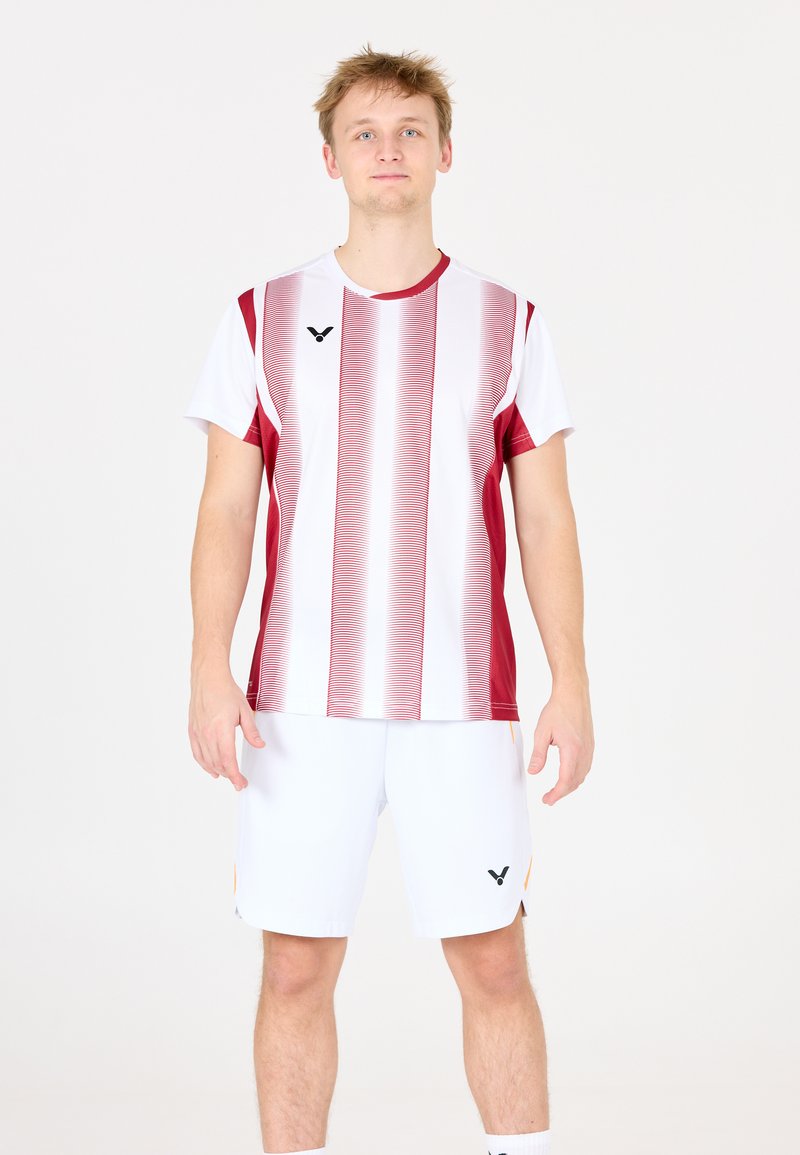 Rød og hvid stribet atletisk skjorte med korte ærmer, parret med hvide shorts med et logo. Glat tekstur, sporty design.