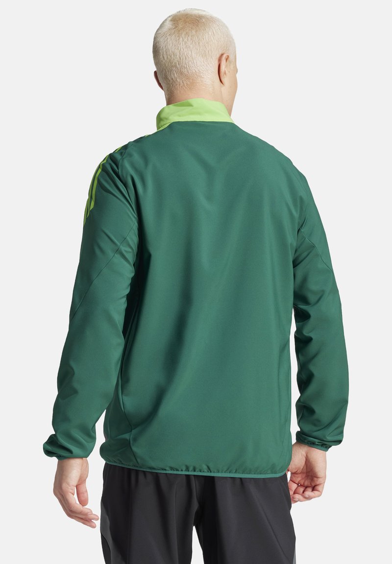 Veste coupe-vent verte avec un grand col, des accents de vert clair contrastants et des manches longues ; texture lisse et design ajusté.