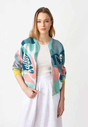 Knit bomber jacket featuring vibrant abstract patterns in teal, pink, and white. Includes a zip front and yellow ribbed cuffs.