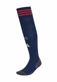 Calcetín deportivo azul marino hasta la rodilla con rayas rojas en la parte superior, plantilla texturizada gris y logotipo blanco en la espinilla.