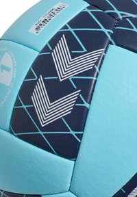 Blå och marinblå fotboll med geometriskt mönster, texturerade paneler och vita chevrondetaljer. Inkluderar en streckkodsetikett på ytan.