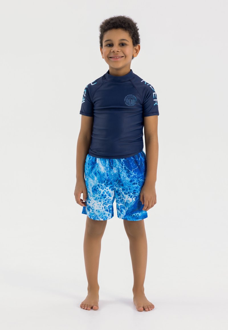 T-shirt de surf bleu à manches courtes, avec un design contrasté sur les épaules, assorti à un short de bain bleu arborant un motif marbré aquatique.