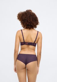 Purple bra and matching brief set. Made of smooth fabric with a seamless design, featuring adjustable straps and delicate edge detailing.