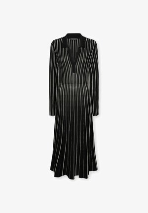 Zwart jurkje met lange mouwen, kraag en V-hals, voorzien van verticale witte strepen en een uitlopende zoom. Gemaakt van een gladde stof.