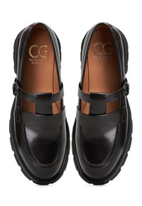 Černé kožené boty s lesklým povrchem, se dvěma pásky přes svršek, kontrastním hnědým interiérem a silnými gumovými podrážkami.