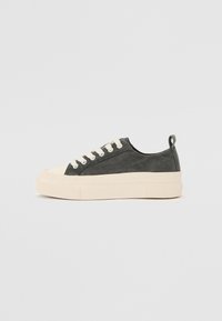 Canvas-Sneaker in Dunkelgrau mit beigen Gummisohlen, runder Zehenpartie und weißen Ösen. Mit einer Stoffschlaufe an der Ferse für ein einfaches Anziehen.