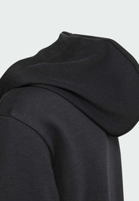 Felpa nera con cappuccio, dal tessuto morbido, con scollatura rotonda e dettagli di cucitura curva sulla spalla.